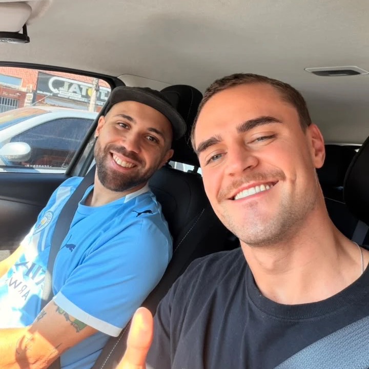 Thiago Bastos e Bonfa, fundadores do Bora Jogar Tênis, sorrindo dentro de um carro